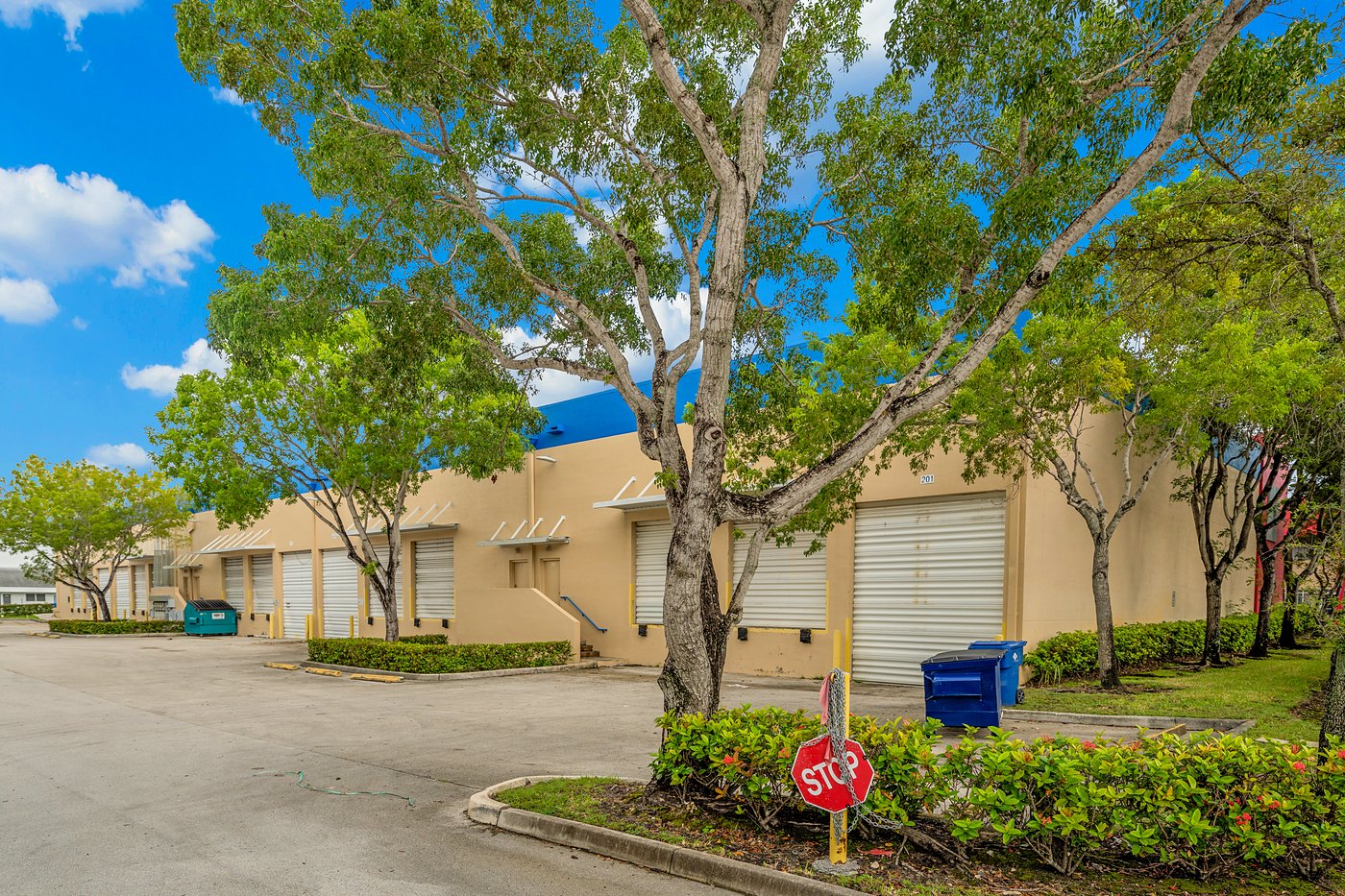 Roll-up doors behind shade trees at Cortland Commercial Center I