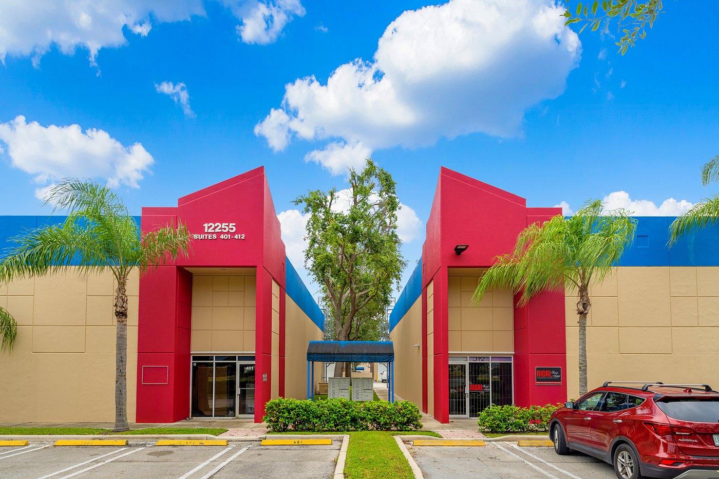 Two red entry towers at 12255 SW 128th Street with palm trees, Cortland Commercial Center II