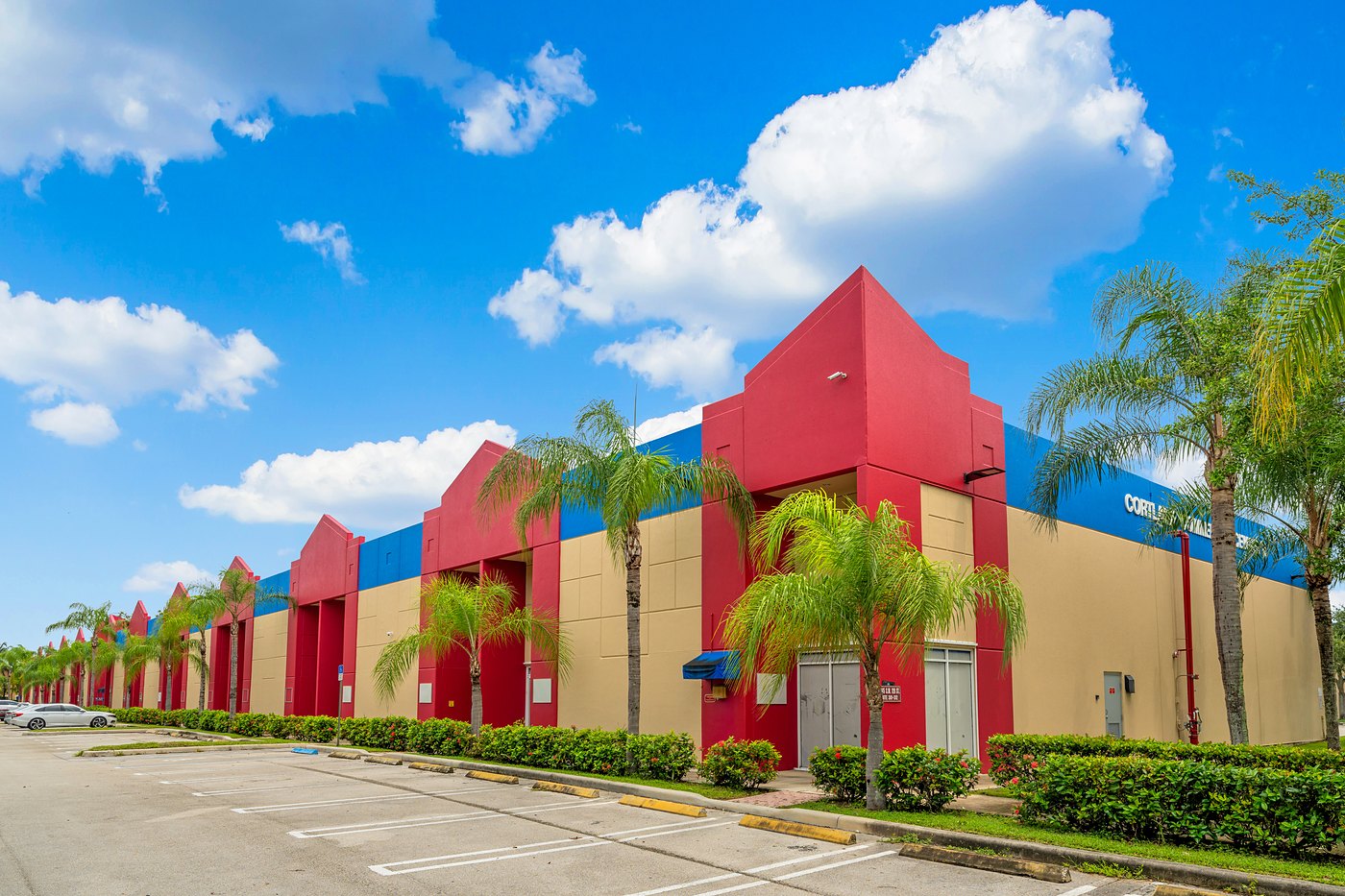 Row of red entry towers and palms along a Cortland Commercial Center II building