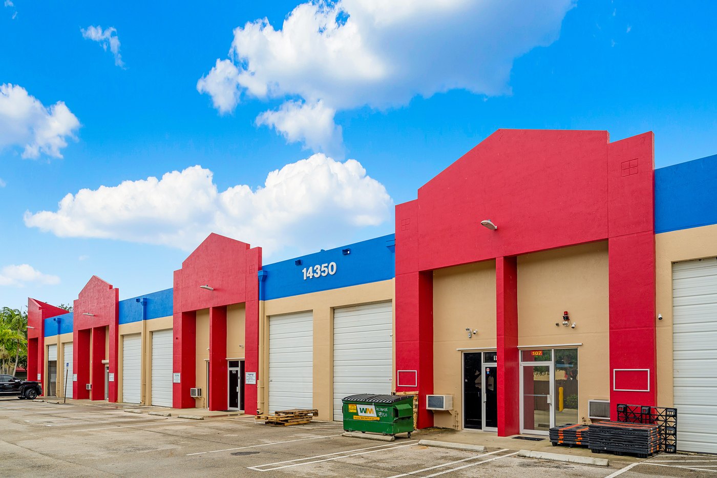 Building number 14350 on the blue parapet above red entry towers and roll-up doors, Zacarias Commercial Center I