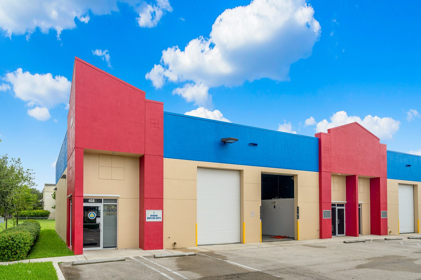 Industrial / flex units with red entry towers and roll-up doors at Zacarias Commercial Center I