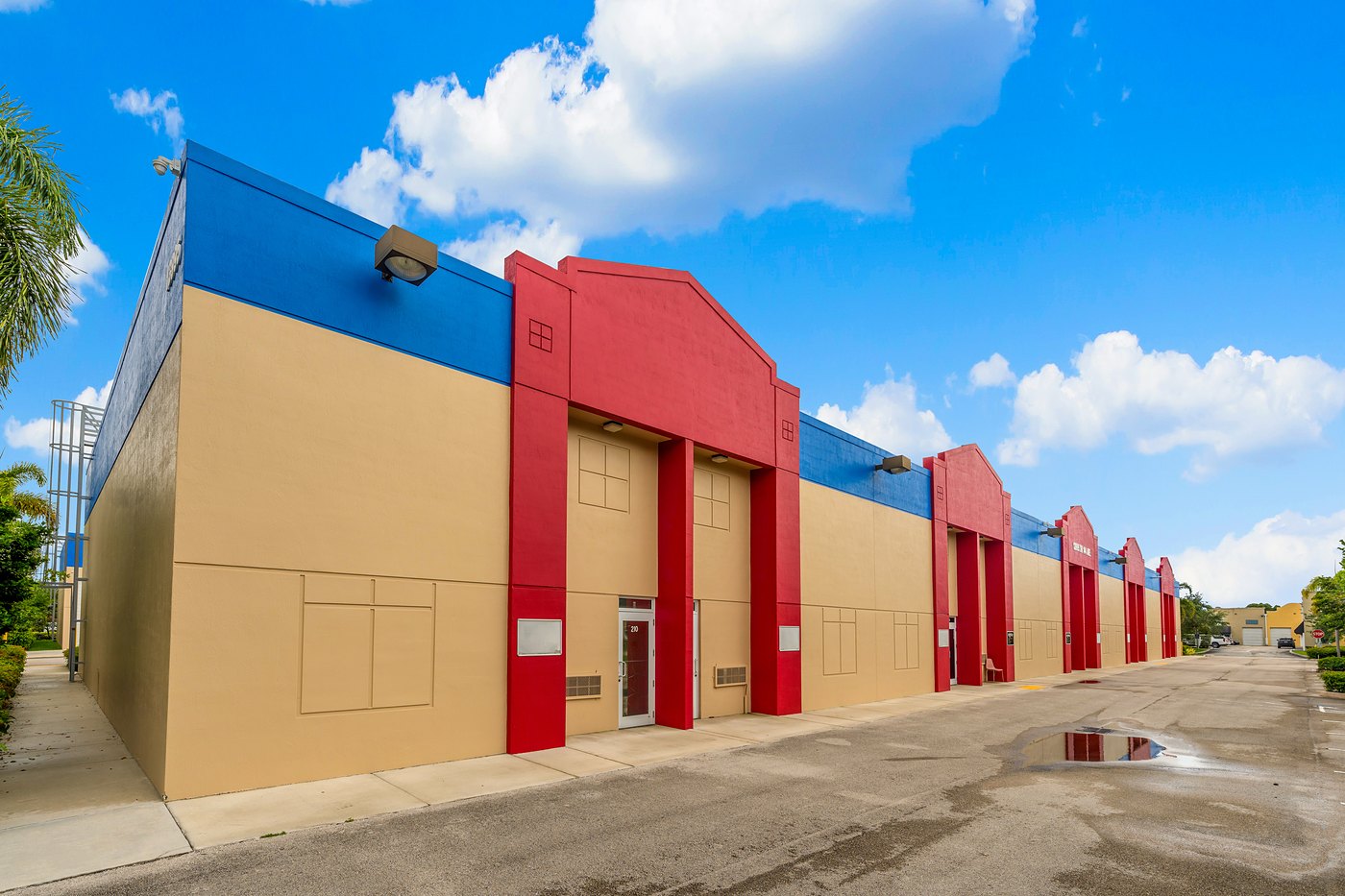 Red entry towers and a blue parapet along a Zacarias Commercial Center II building