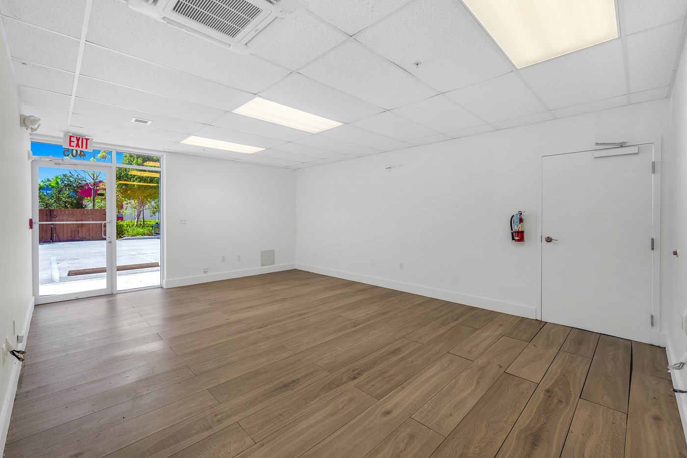 Finished office space with wood-look flooring and a glass door, Zacarias Commercial Center III