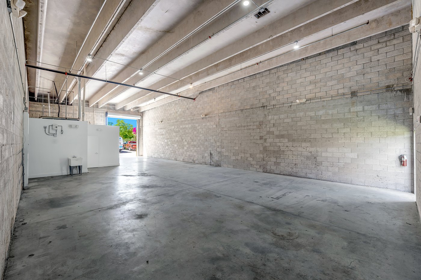 Wide view of a warehouse bay with block walls and an office build-out, Zacarias Commercial Center III